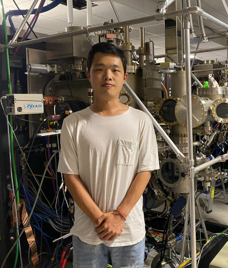 Yongchen posing in front of a Molecular Beam Epitaxy machine